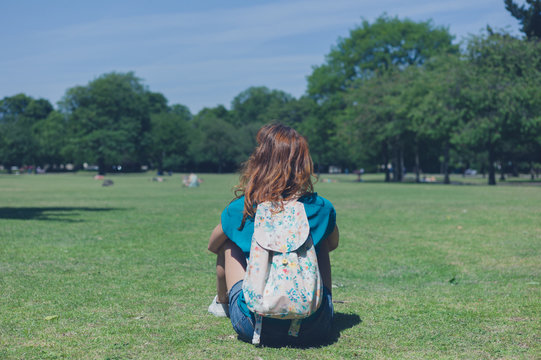 Young woman with backpack relaxing in park