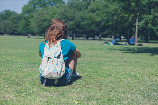 Young woman with backpack relaxing in park