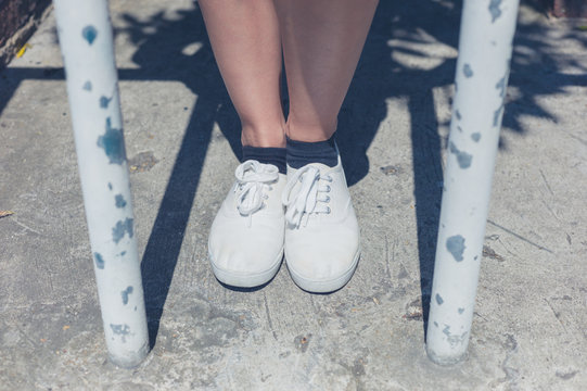 Legs of young woman by bars