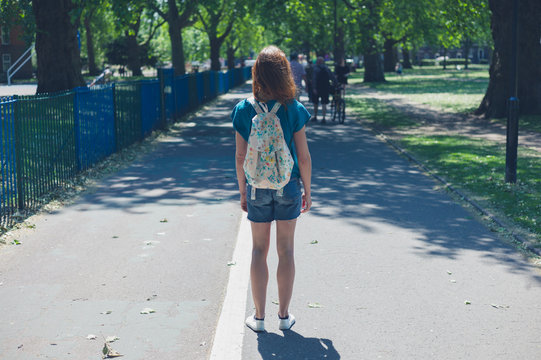Young woman with backpack in park
