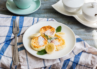 cottage cheese pancakes with banana, powdered sugar and fresh mi