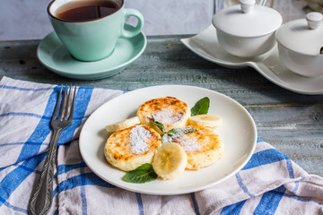 cottage cheese pancakes with banana, powdered sugar and fresh mi