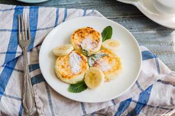 cottage cheese pancakes with banana, powdered sugar and fresh mi