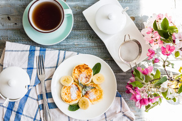 cottage cheese pancakes with banana, powdered sugar and fresh mi