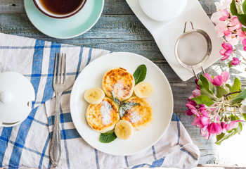 cottage cheese pancakes with banana, powdered sugar and fresh mi