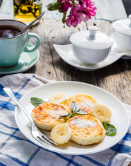 pancakes from cottage cheese  with banana, powdered sugar and mi