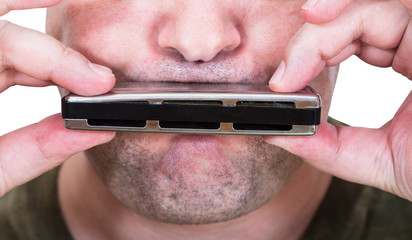 unshaven street musician playing harmonica