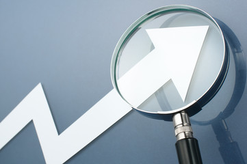 Looking upside growth arrow with magnifying glass. Concept image