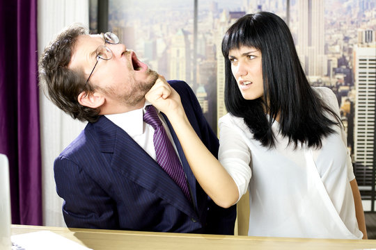 Unhappy business woman hitting boss in face