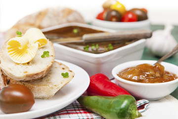 Slices of bread and butter with tomatoes, peppers, chutney and p