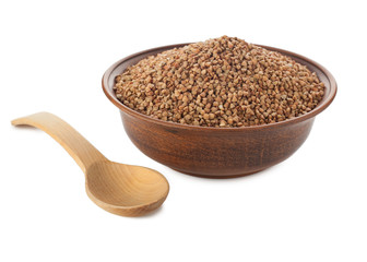 Buckwheat in bowl with wooden spoon on white.