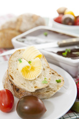 Slices of bread and butter with tomatoes, peppers and pate