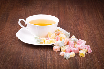 Tea in a white cup and saucer, a scattering of Turkish Delight