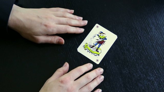 hand taking out ace up your sleeve joker