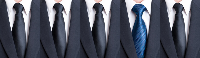 Blue tie between black neckties