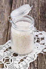 Rice in glass jar on white lace napkin.