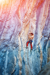 Rock climber climbing up a cliff