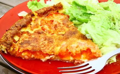 part de quiche aux tomate,lardon et fromage avec salade