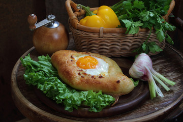 Open pie with an egg submitted on leaves of green salad