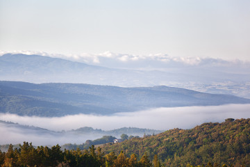 Morning fog over the village and hills in Tuscany