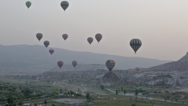 Multi-colored balloons fly over rocks.The greatest tourist attraction of Cappadocia , the flight with the balloon