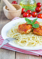 Meatballs in tomato sauce with spaghetti on a white plate