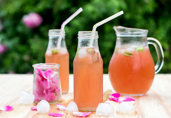 Rhubarb hibiscus iced tea with rose petals in the garden
