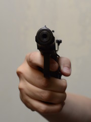 gun in hand on gray background