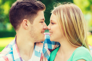smiling couple touching noses in park