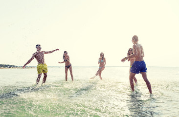 happy friends having fun on summer beach