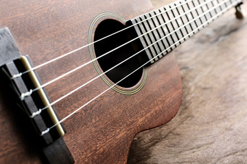 Close up of ukulele on old wood background with soft light