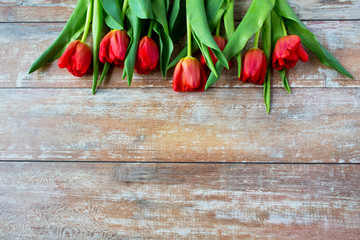 close up of red tulips on wooden background