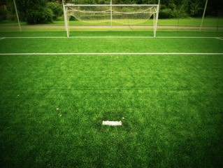 Football playground view of grass field, gate at the end. 