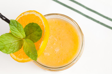 Banana orange cocktail with orange and mint decoration.