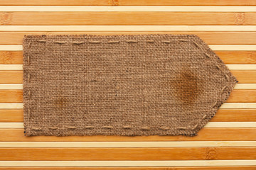 Arrow made of burlap lies on a bamboo mat