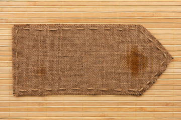 Arrow made of burlap lies on a bamboo mat