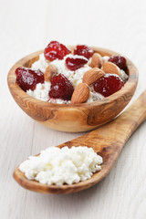 cottage cheese with preserved strawberry in wood bowl on oak