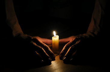 Candle, hands, flame, wood.