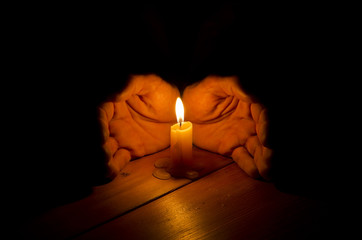 Candle, hands, flame, wood.