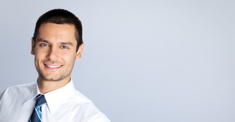 Portrait of cheerful businessman, against grey