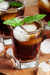 Cold drink with cola, ice and mint, selective focus