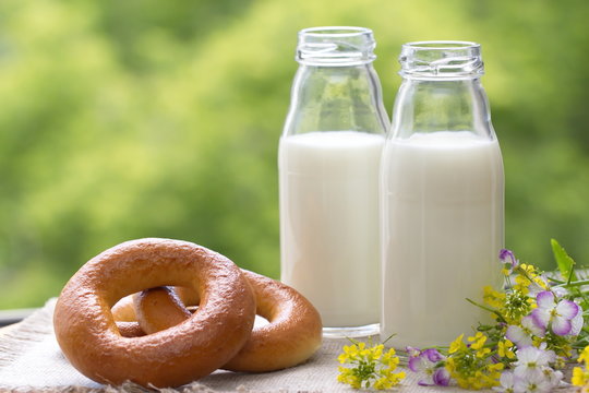 Bottle of milk and bagels in summer time