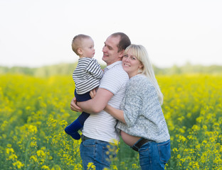 Fototapeta premium family from three people on a rape field