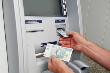 hand of a man using banking machine