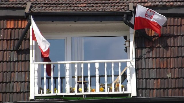 Polish flags waving on roof balcony