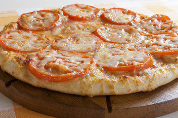 Margherita - Pizza with tomato and cheese on a wooden board.