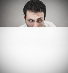 Man hiding behind a white carboard