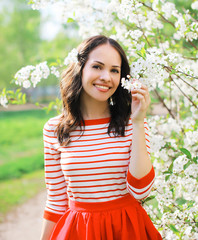 Portrait of a beautiful young woman in flowering garden