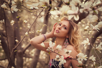Beauty smiling woman near white magnolia