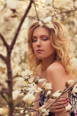 Beauty smiling woman near white magnolia